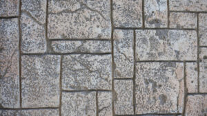 Sea Breeze A close-up of a stone wall made up of rough, rectangular blocks fitted together. The textured surface is uneven and weathered, resembling the rugged charm one might find along a sea breeze-kissed shoreline. Floor And Window Cleaning